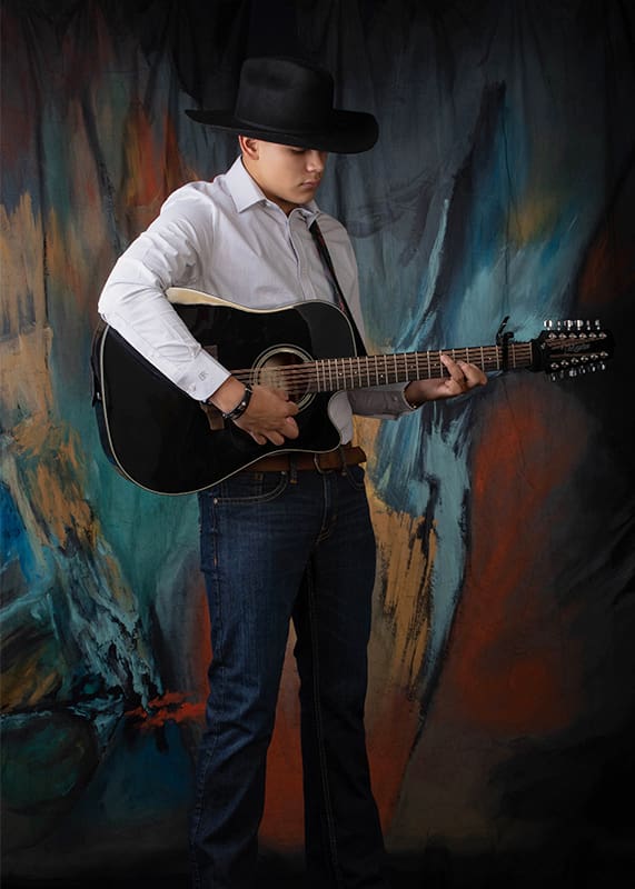 Evoto young man with black guitar and cowboy hat<br />